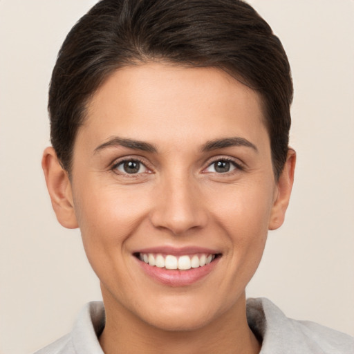 Joyful white young-adult female with short  brown hair and brown eyes