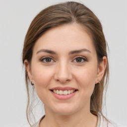 Joyful white young-adult female with medium  brown hair and grey eyes