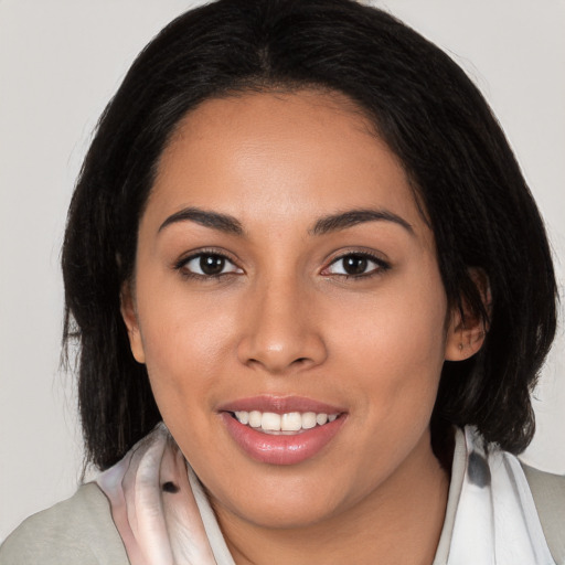 Joyful latino young-adult female with medium  brown hair and brown eyes