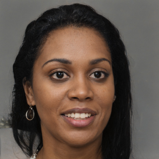 Joyful black young-adult female with long  black hair and brown eyes