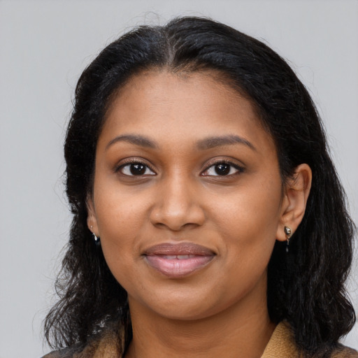 Joyful black young-adult female with long  brown hair and brown eyes