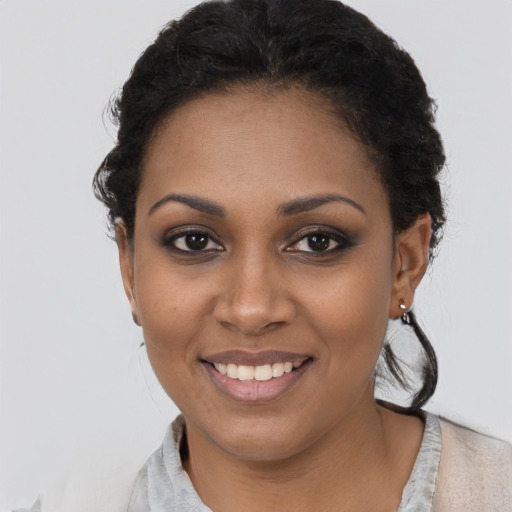 Joyful black young-adult female with short  black hair and brown eyes