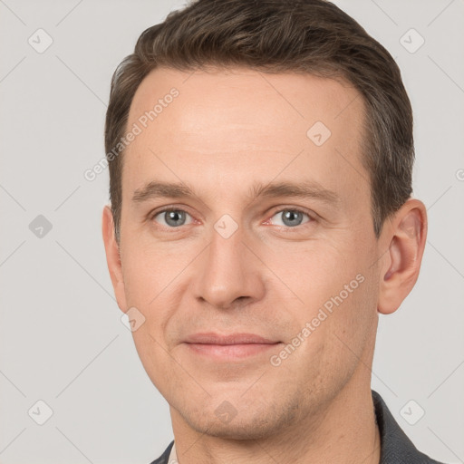 Joyful white adult male with short  brown hair and grey eyes