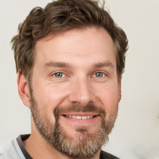 Joyful white adult male with short  brown hair and grey eyes