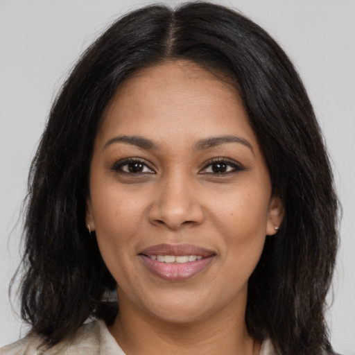Joyful black young-adult female with long  brown hair and brown eyes