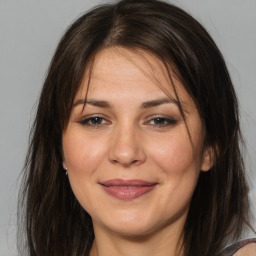 Joyful white adult female with long  brown hair and brown eyes