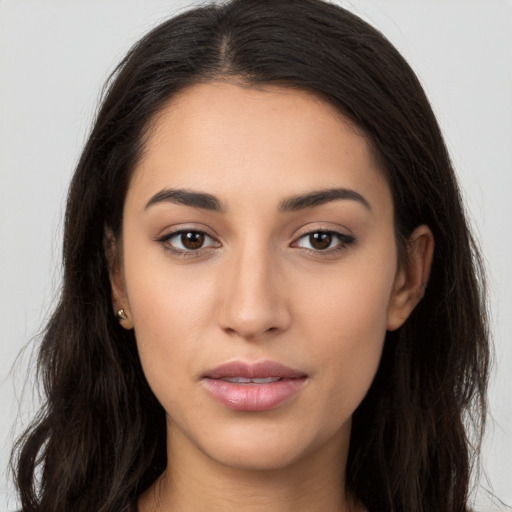 Joyful latino young-adult female with long  brown hair and brown eyes