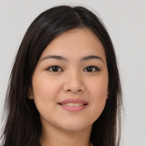 Joyful asian young-adult female with long  brown hair and brown eyes
