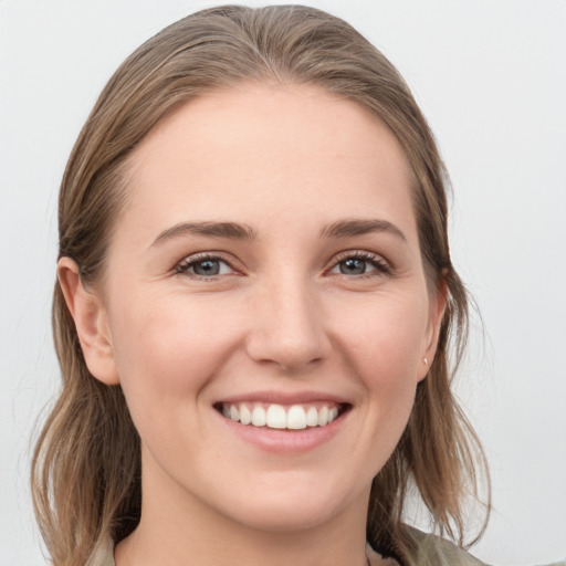 Joyful white young-adult female with medium  brown hair and grey eyes