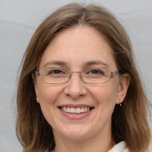 Joyful white adult female with medium  brown hair and blue eyes