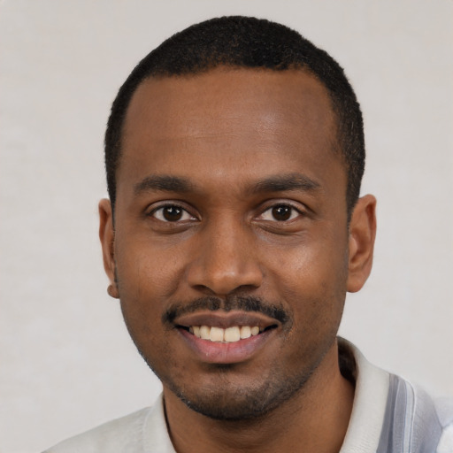 Joyful black young-adult male with short  black hair and brown eyes