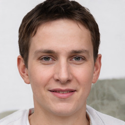 Joyful white young-adult male with short  brown hair and grey eyes