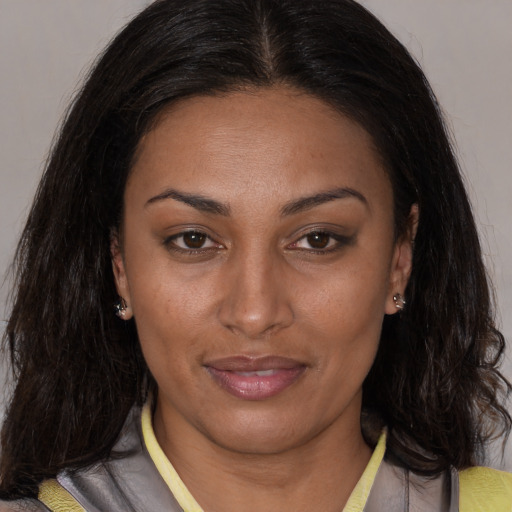 Joyful latino adult female with medium  brown hair and brown eyes