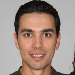 Joyful white young-adult male with short  black hair and brown eyes