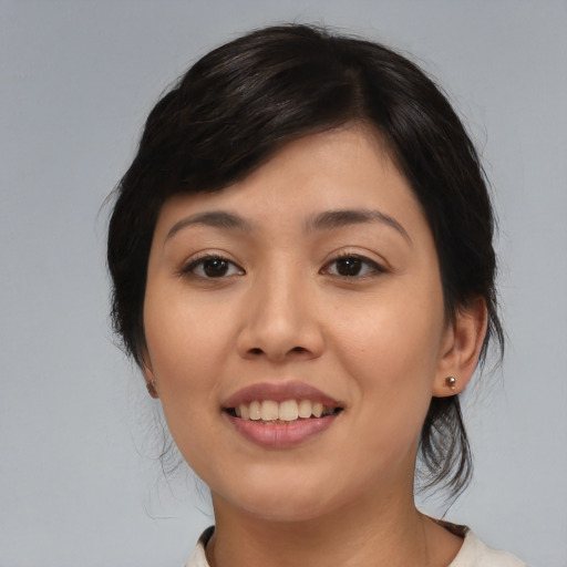 Joyful asian young-adult female with medium  black hair and brown eyes