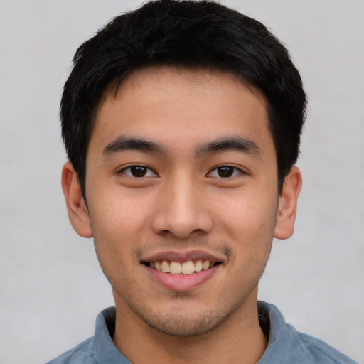 Joyful asian young-adult male with short  black hair and brown eyes