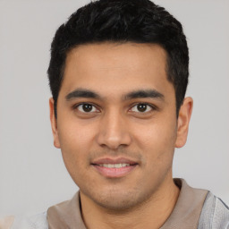Joyful latino young-adult male with short  black hair and brown eyes