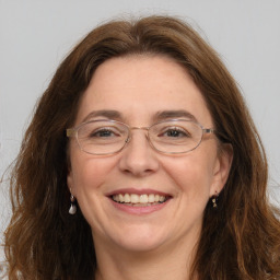 Joyful white adult female with long  brown hair and grey eyes