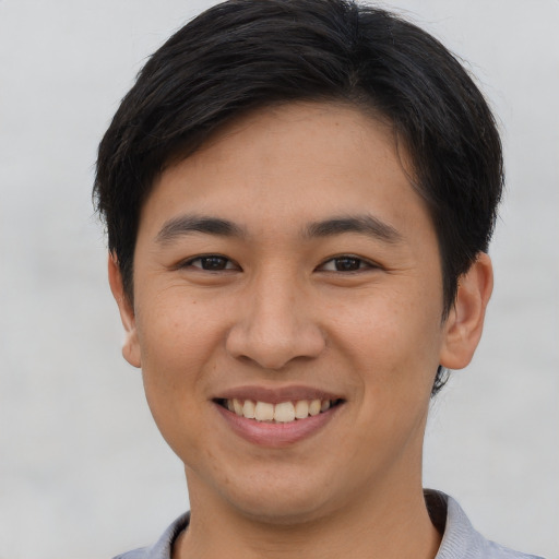 Joyful asian young-adult male with short  brown hair and brown eyes