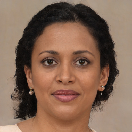 Joyful black adult female with medium  brown hair and brown eyes