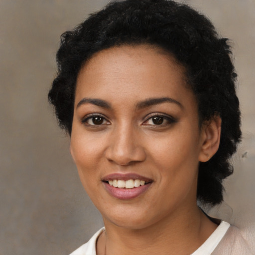 Joyful black young-adult female with short  black hair and brown eyes