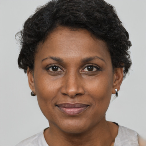 Joyful black adult female with short  brown hair and brown eyes