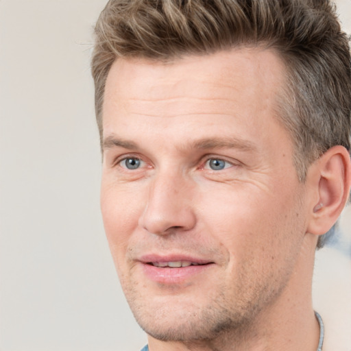 Joyful white adult male with short  brown hair and grey eyes