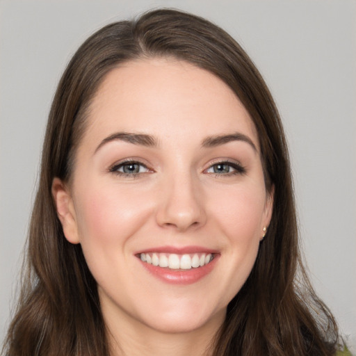 Joyful white young-adult female with long  brown hair and grey eyes