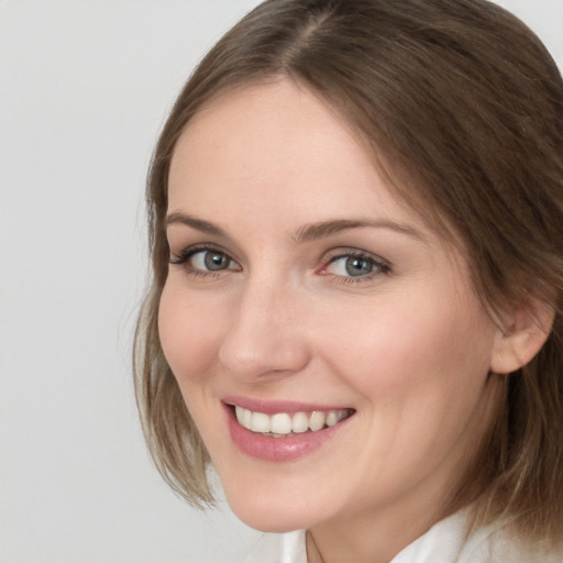 Joyful white young-adult female with medium  brown hair and blue eyes