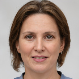 Joyful white adult female with medium  brown hair and grey eyes