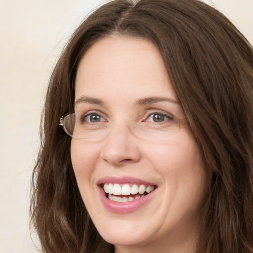 Joyful white young-adult female with long  brown hair and green eyes