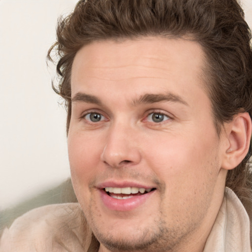 Joyful white young-adult male with medium  brown hair and grey eyes