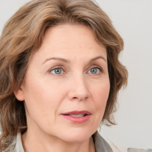 Joyful white adult female with medium  brown hair and blue eyes