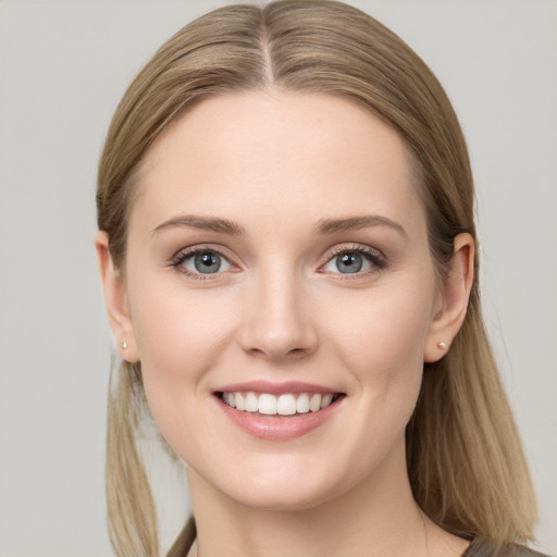 Joyful white young-adult female with long  brown hair and blue eyes