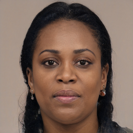 Joyful black young-adult female with long  brown hair and brown eyes