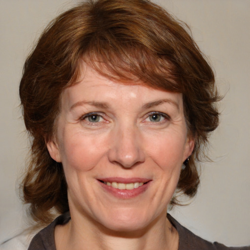 Joyful white adult female with medium  brown hair and blue eyes