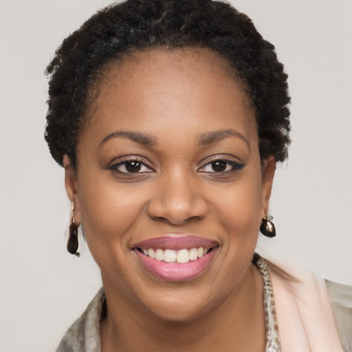 Joyful black young-adult female with short  brown hair and brown eyes