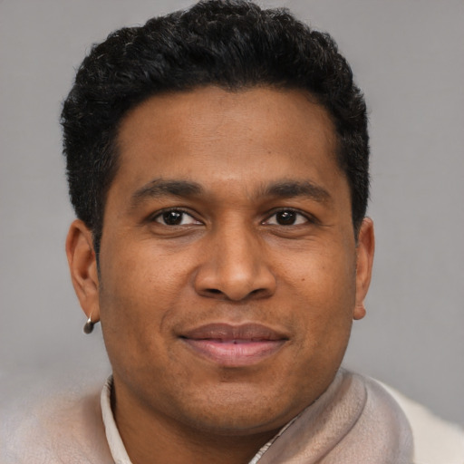 Joyful black young-adult male with short  brown hair and brown eyes