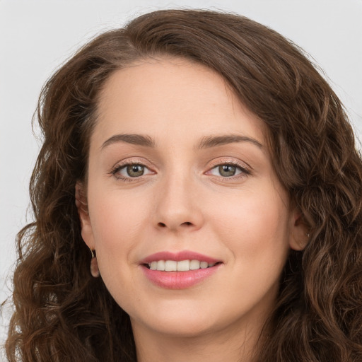 Joyful white young-adult female with long  brown hair and green eyes