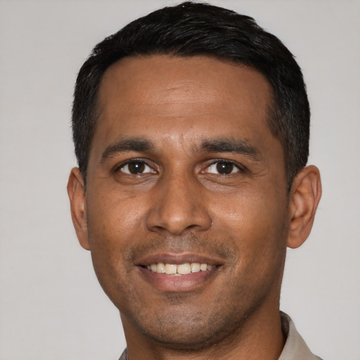 Joyful latino young-adult male with short  black hair and brown eyes