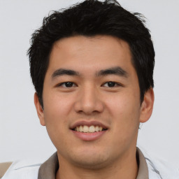 Joyful asian young-adult male with short  brown hair and brown eyes