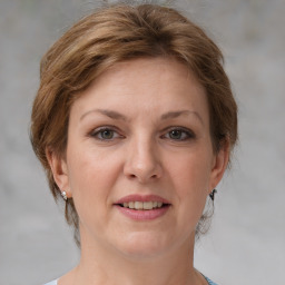 Joyful white adult female with medium  brown hair and grey eyes