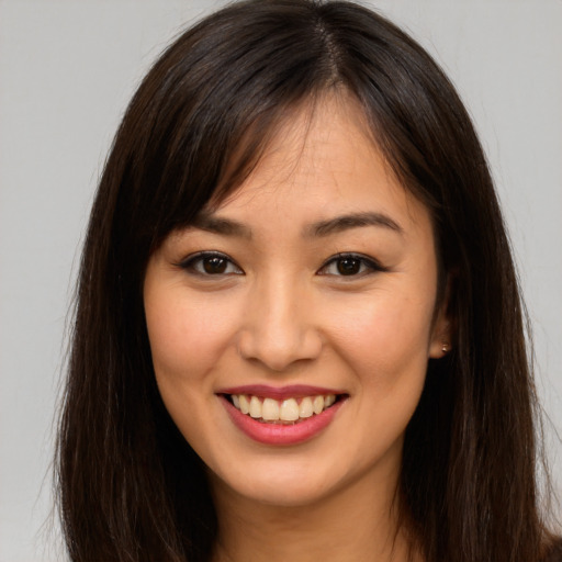 Joyful asian young-adult female with long  brown hair and brown eyes