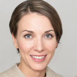 Joyful white young-adult female with medium  brown hair and grey eyes