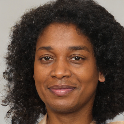 Joyful black adult female with medium  brown hair and brown eyes