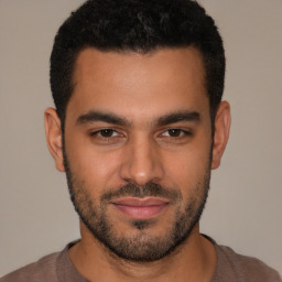 Joyful latino young-adult male with short  black hair and brown eyes