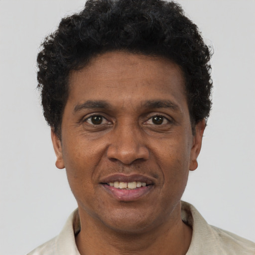 Joyful black adult male with short  brown hair and brown eyes