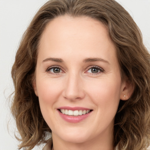 Joyful white young-adult female with long  brown hair and green eyes