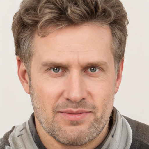 Joyful white adult male with short  brown hair and grey eyes