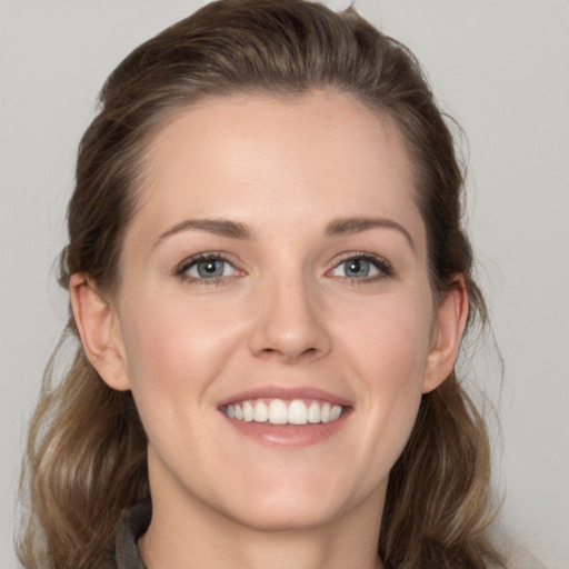 Joyful white young-adult female with medium  brown hair and grey eyes